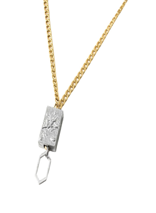 The Anne Marie Chagnon Borocay Necklace features a medium weight gold cuban link style chain with a rectangular pewter pendant with a suspended hexagon bead detail